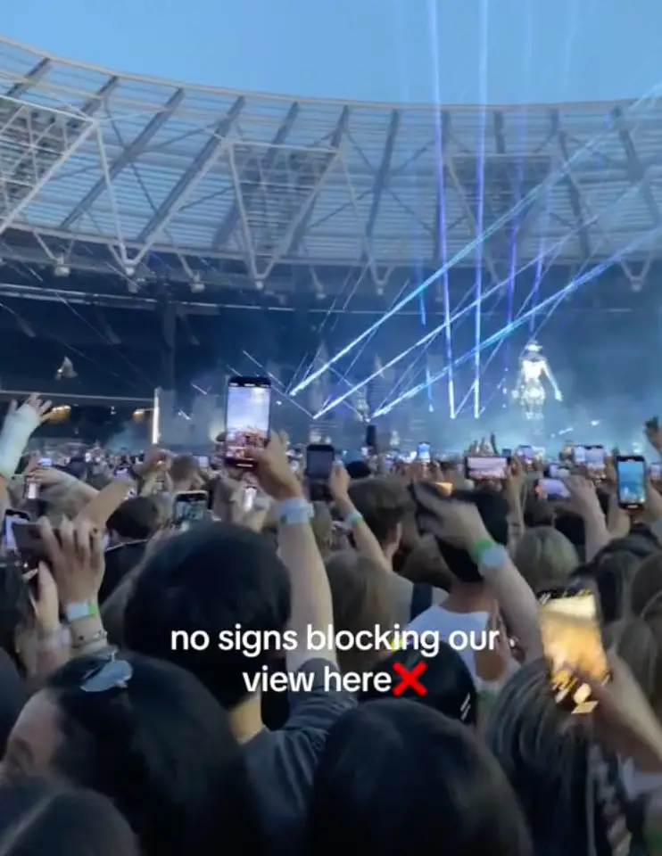 The now empty-handed sign holder doesn't seem to clock who snatched it.