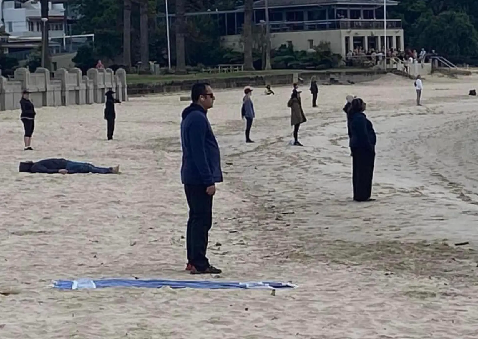 The group were pictured standing separately on the beach.