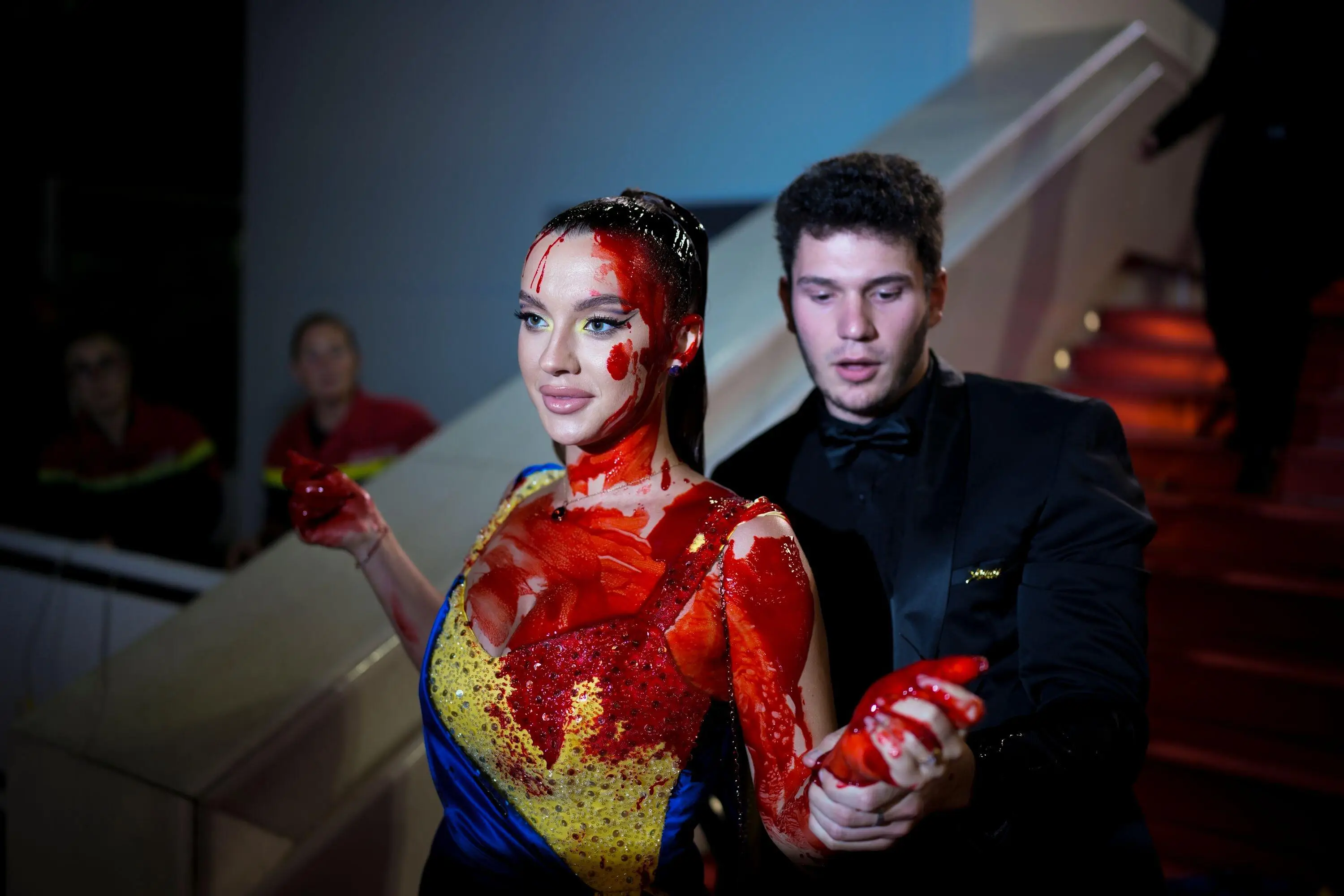 The protester being escorted from the red carpet.