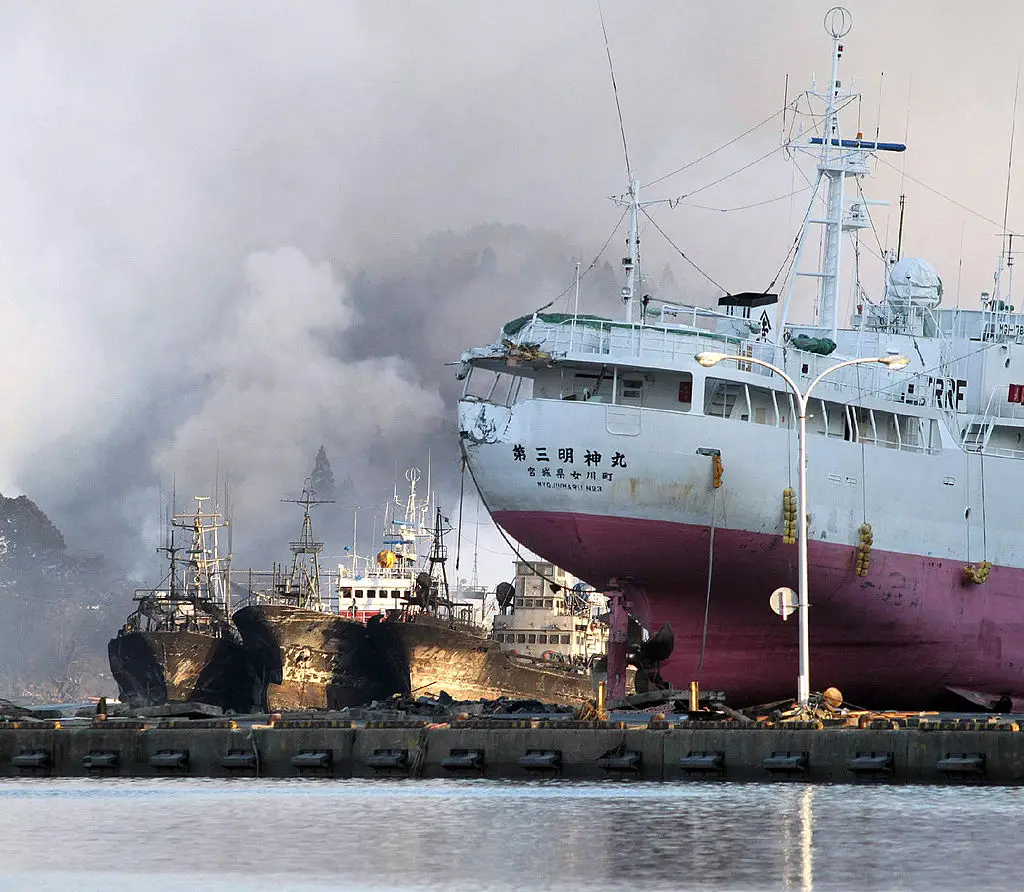White smokes rise from fishing boats at the port of Kesennuma, in Miyagi prefecture, following the tsunami that hit Japan in March 2011 (STR/AFP via Getty Images)