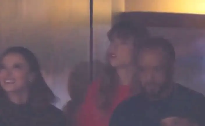 Swift is seen saying something aloud.