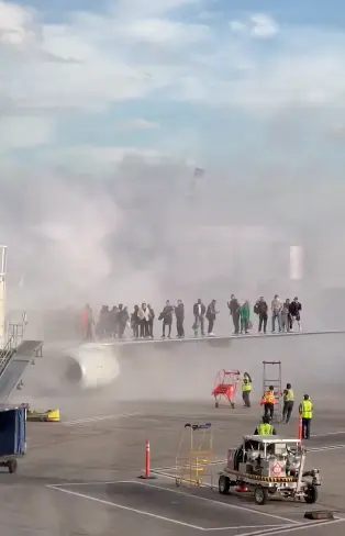 Dozens of passengers could be seen cramming on the wings of the jet as it caught fire (Twitter/@flynnstone)