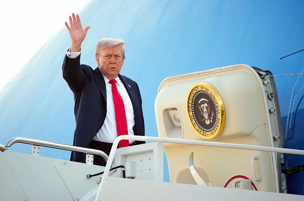 President Donald Trump waves to the cameras as he boards Air Force One on his way to meeting President Vladimir Putin in Alaska (Andrew Harnik/Getty Images)