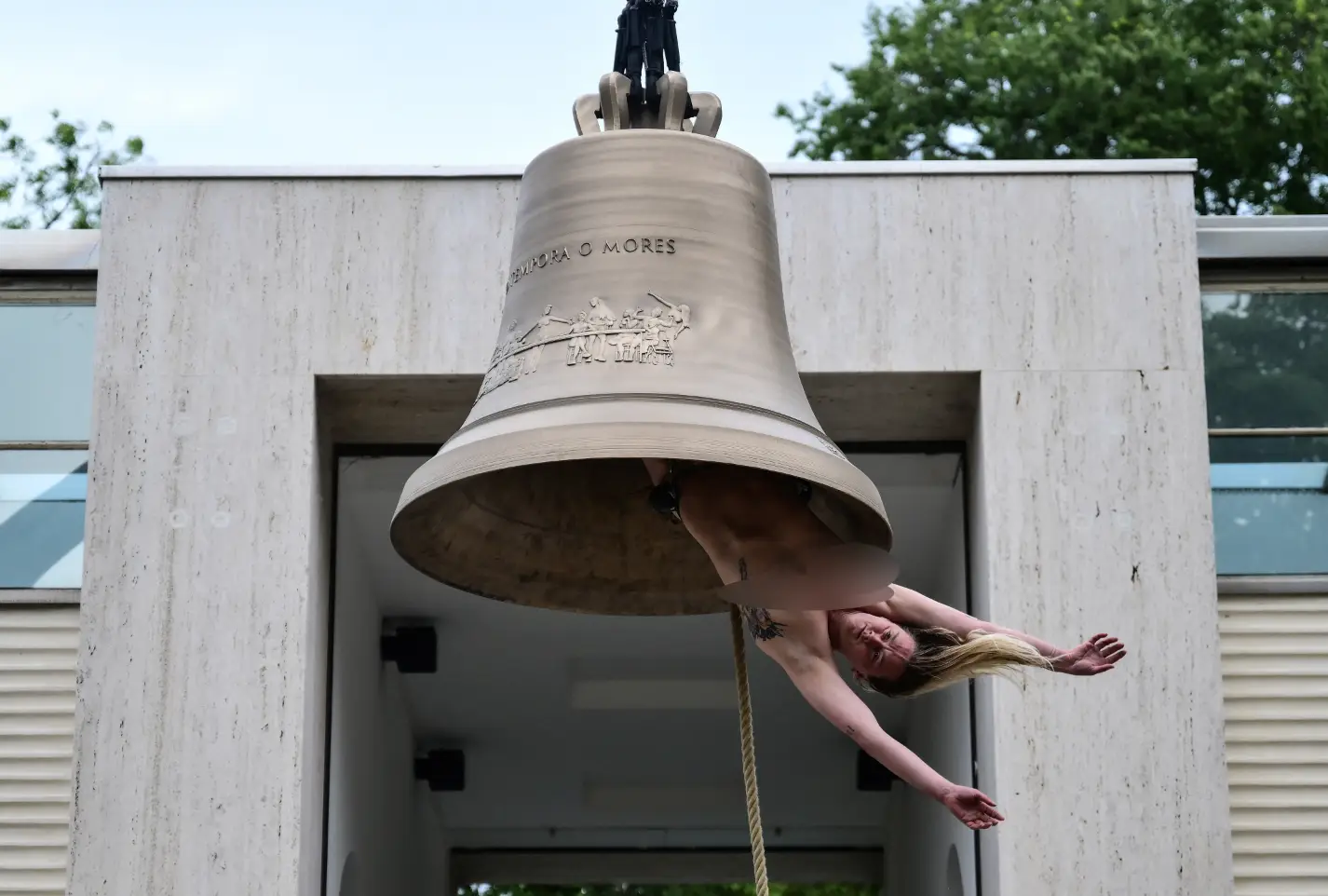 Florentina Holzinger hangs upside down naked from a giant bell (MARCO BERTORELLO / AFP via Getty Images)