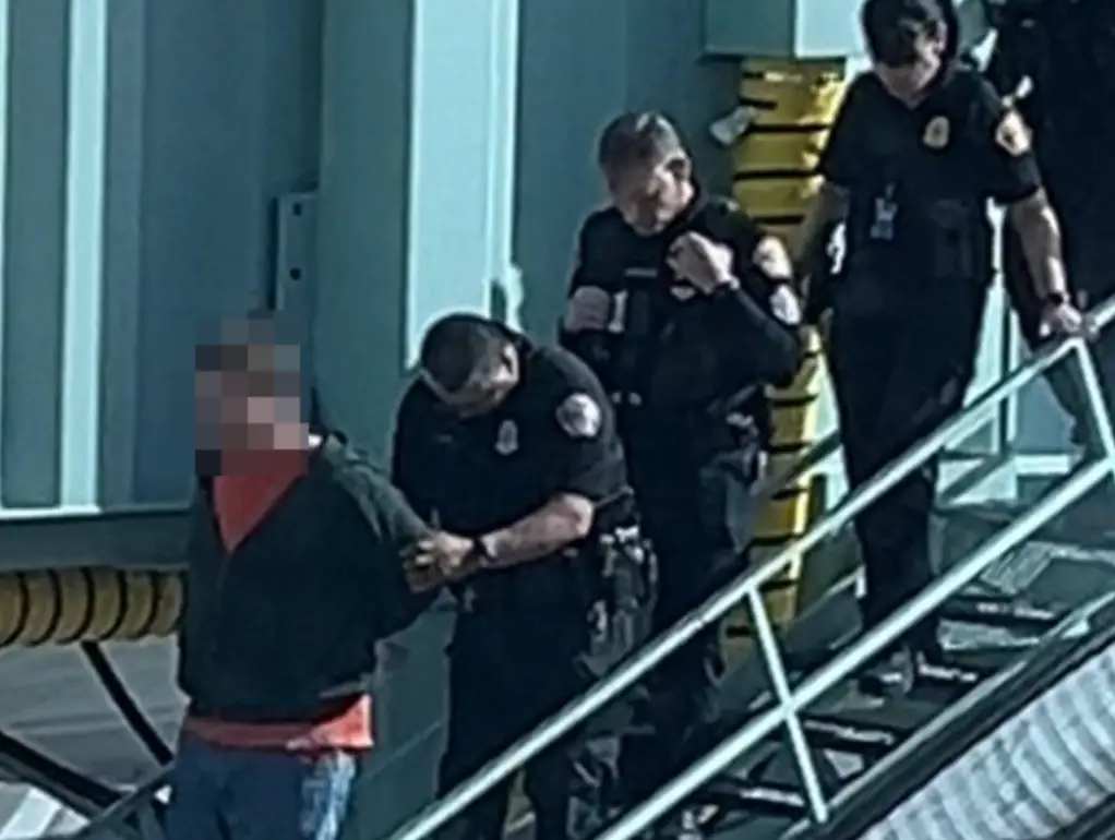 Etkind shared an image of the man being escorted from the plane.