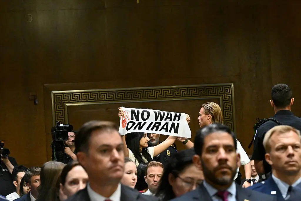 A protestor carries a 'no war on Iran' sign (Alex WROBLEWSKI / AFP via Getty Images)