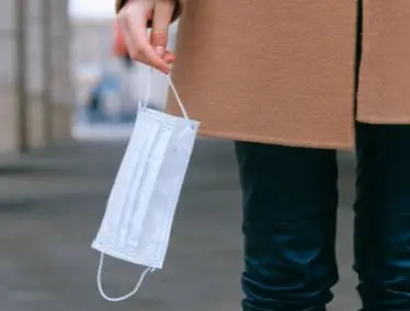Person holding face mask (Pexels)
