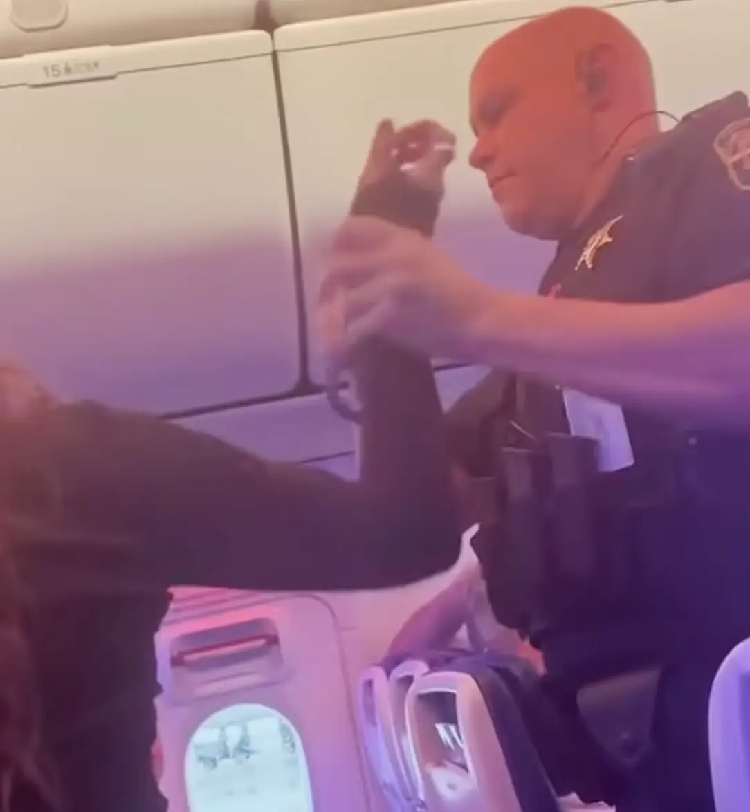 The woman was removed from the plane by law enforcement officers.