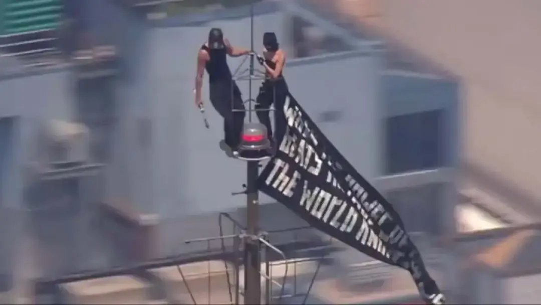 The pair, who are well known 'daredevil climbers' were pictured holding a sign that read: "When the power of love beats the love of power the world knows peace." Featured Image