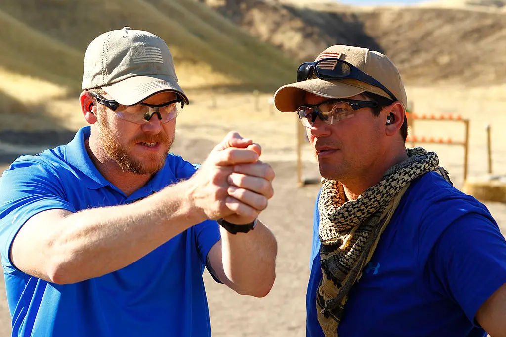 Kyle pretends to aim down a barrel of a gun, pictured with Dean Cain. (Trae Patton/NBCU Photo Bank/NBCUniversal via Getty Images via Getty Images)