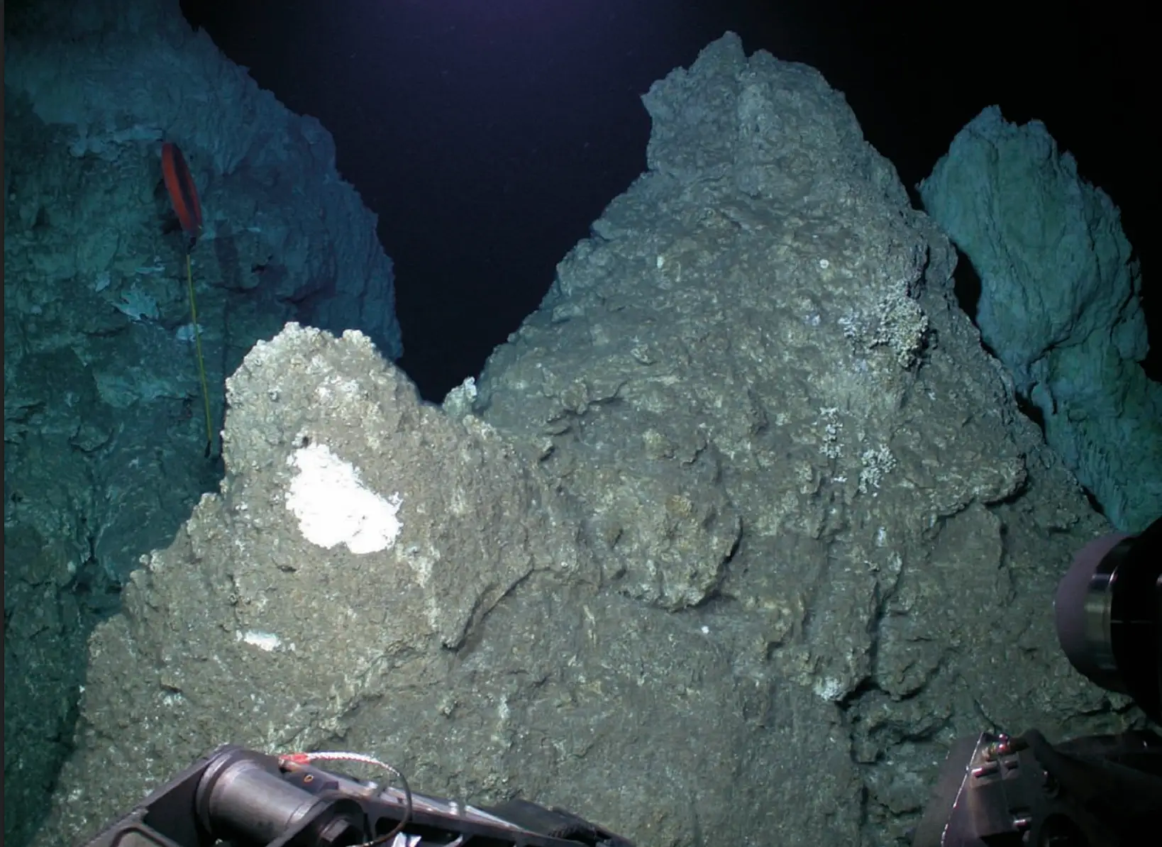 Th e brown-grey chimney in the foreground is an old, extinct deposit located at the summit of Poseidon. (D. Kelley/UW/URI-IAO/NOAA)