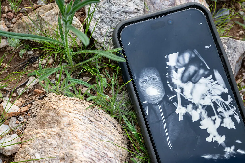 Nancy Guthrie's alleged kidnapper is seen on FBI Director Kash Patel's X account on a cellular phone (Brandon Bell/Getty Images)