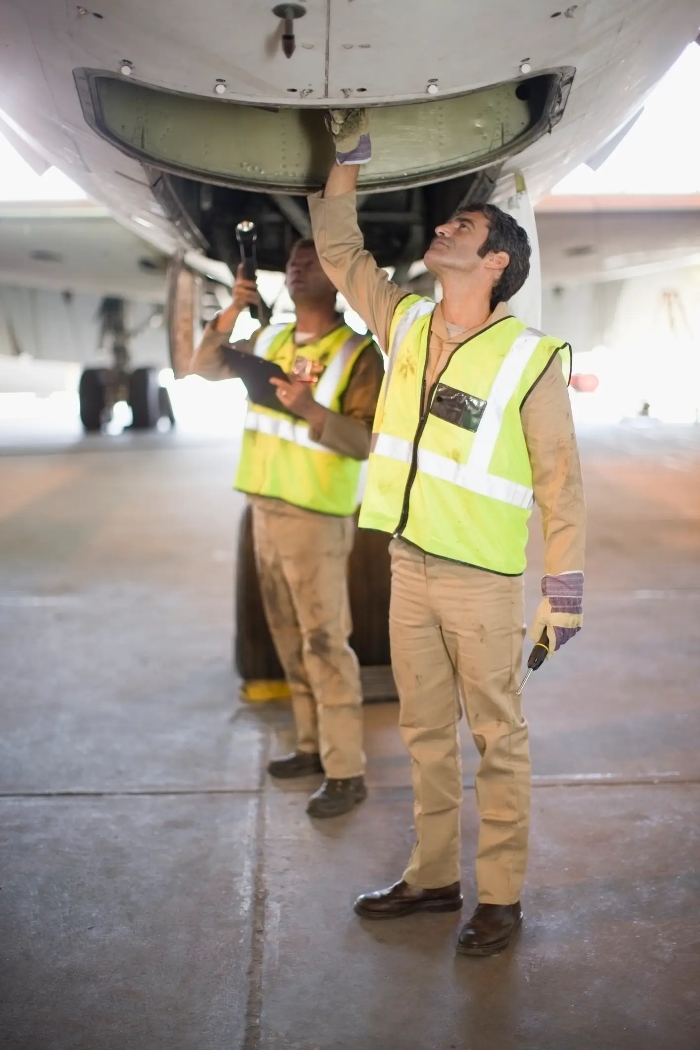 Aviation workers check the wheel well of an aircraft (Getty stock)