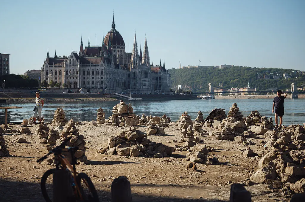 Following weeks of extreme heat and prolonged drought, the receding river has exposed large sections of the riverbed, rocks and sandbars along the capital's waterfront. (Photo by Robert Nemeti/Anadolu via Getty Images)