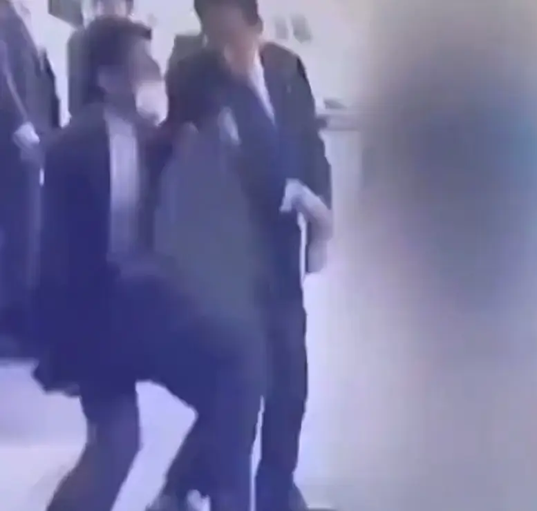 Opening up his briefcase to reveal it's actually a kevlar bullet shield, the bodyguard ushered his boss away from danger.