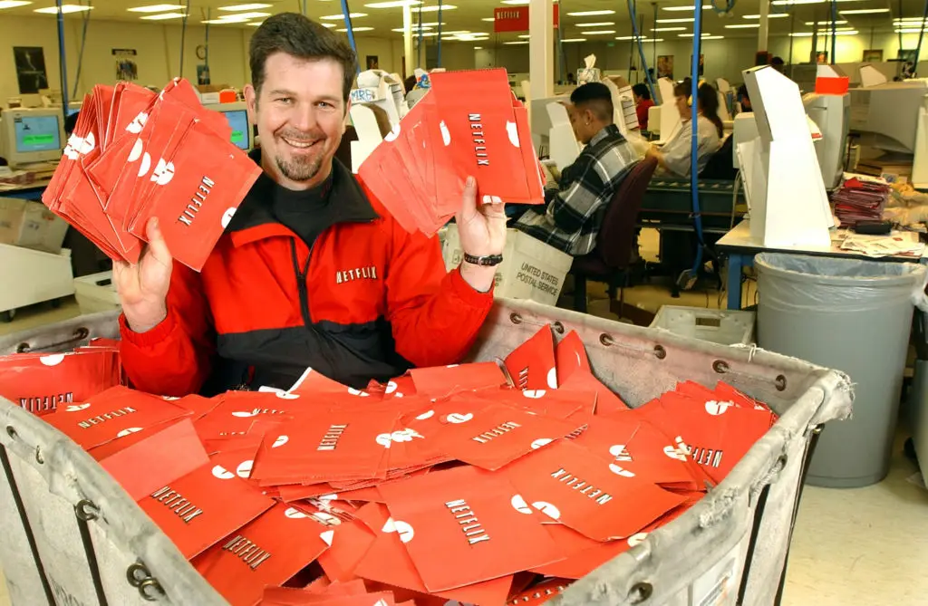 Then-Netflix CEO Reed Hastings with a cart full of ready-to-be-shipped DVDs in 2002 (Photo By Justin Sullivan/Getty Images)