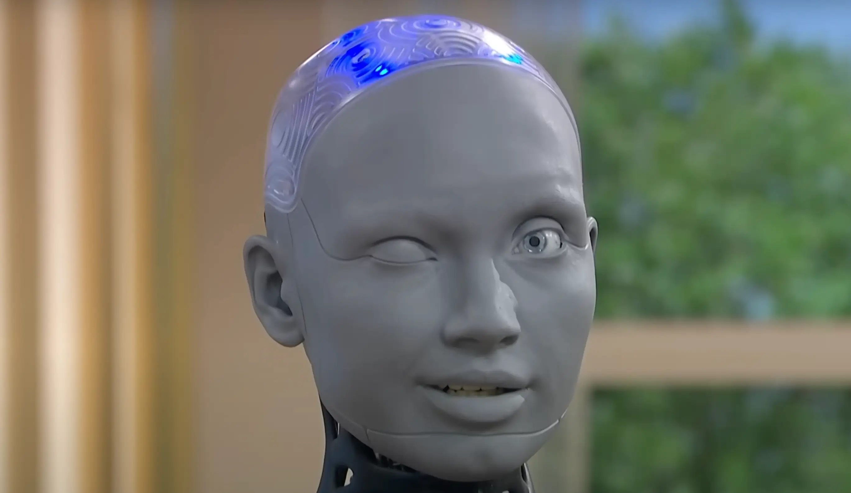 Ameca winks at the camera as the interviewers talk about the dangers of AI (ITV)