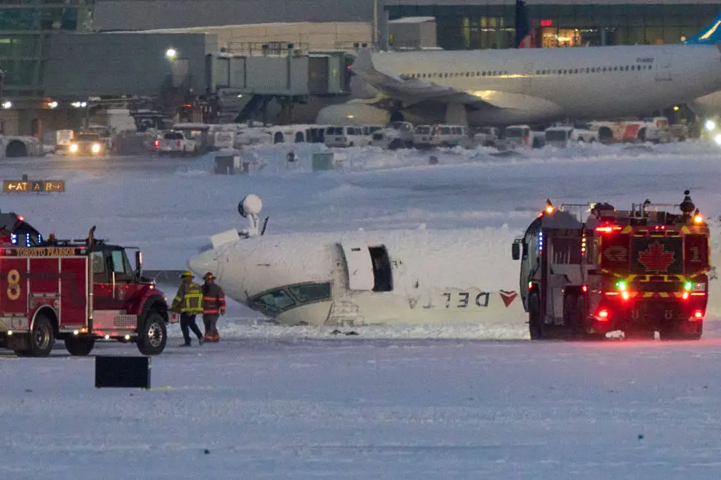 A Delta airlines plane sits on its roof after crashing upon landing at Toronto Pearson Airport in Toronto, Ontario, on Monday (GEOFF ROBINS/AFP via Getty Images)