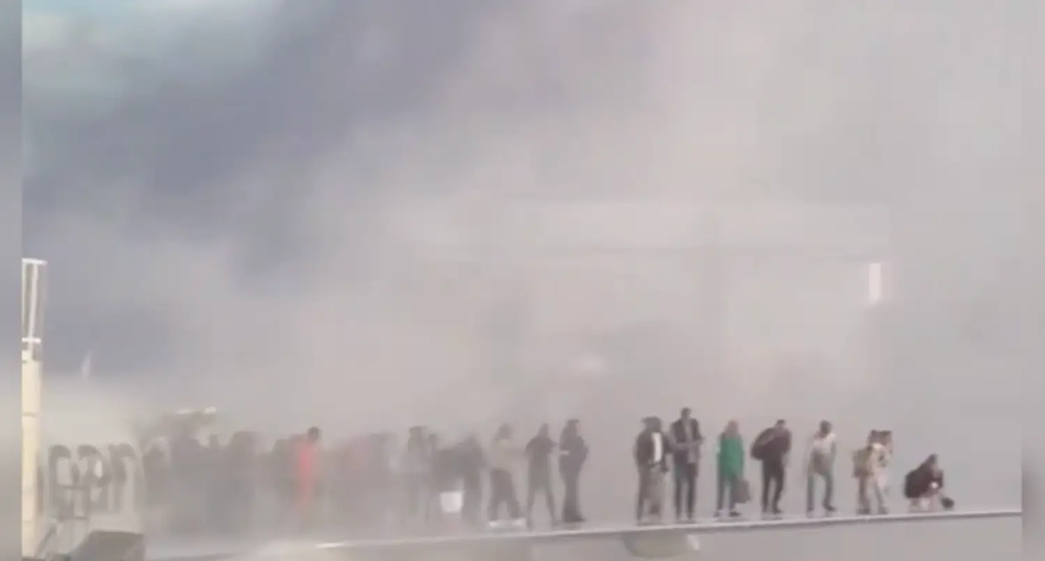 The passengers could be seen huddling on the wing as smoke billowed (X/flynnstone)