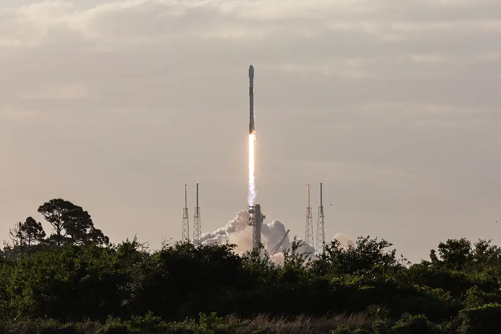 A SpaceX Falcon 9 rocket lifting off from a base (Manuel Mazzanti/NurPhoto via Getty Images)