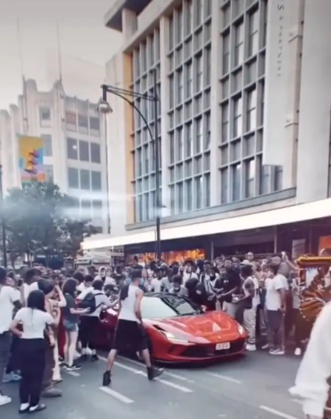 Luxury cars tried to make their way through the crowd.