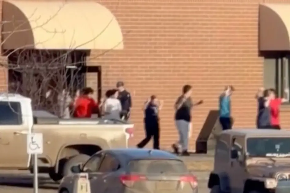 Students were led out of the school with their hands up after sheltering in classrooms (Jordon Kosik via AP)