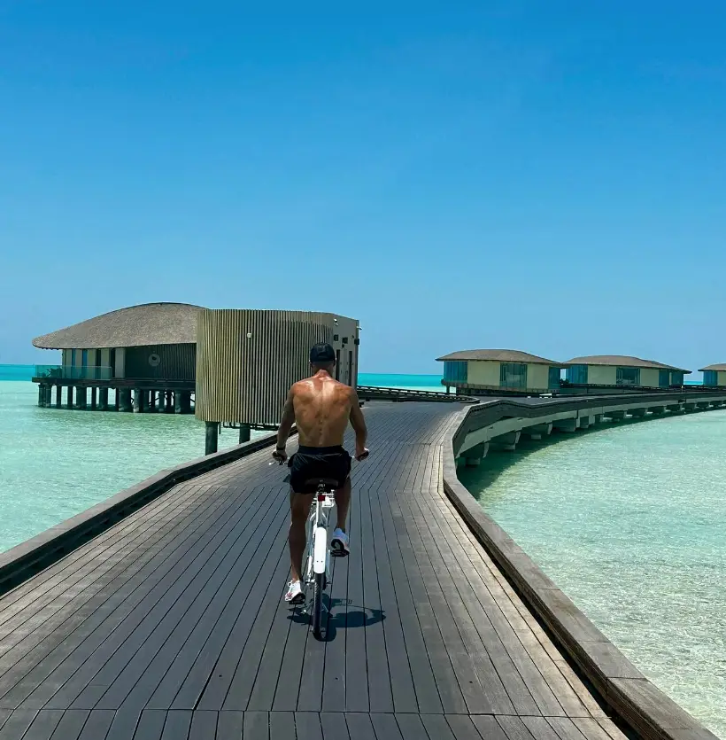 Ronaldo having a bike ride down the walkway to the overwater villas (Instagram / @cristiano)