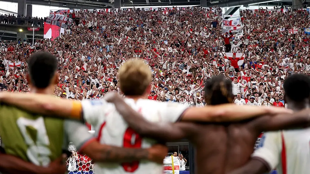 England players standing arm in arm in front of fans. (Joosep Martinson - FIFA/FIFA via Getty Images )