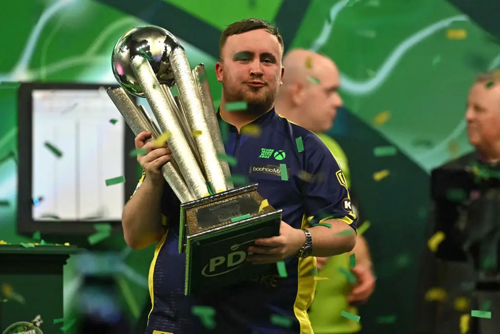 Luke Littler picks up the World Darts Championship. (Ben Stansall/Getty)