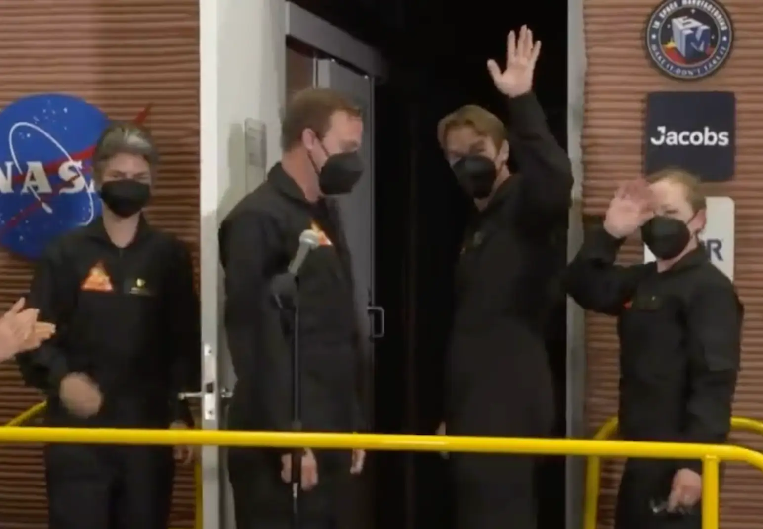The crew waved goodbye as they made their way into the chamber.