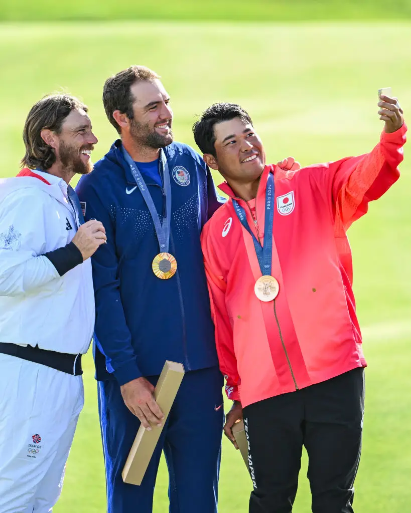 The golf medallists took a quick snap on the podium. (Keyur Khamar/PGA TOUR via Getty Images)