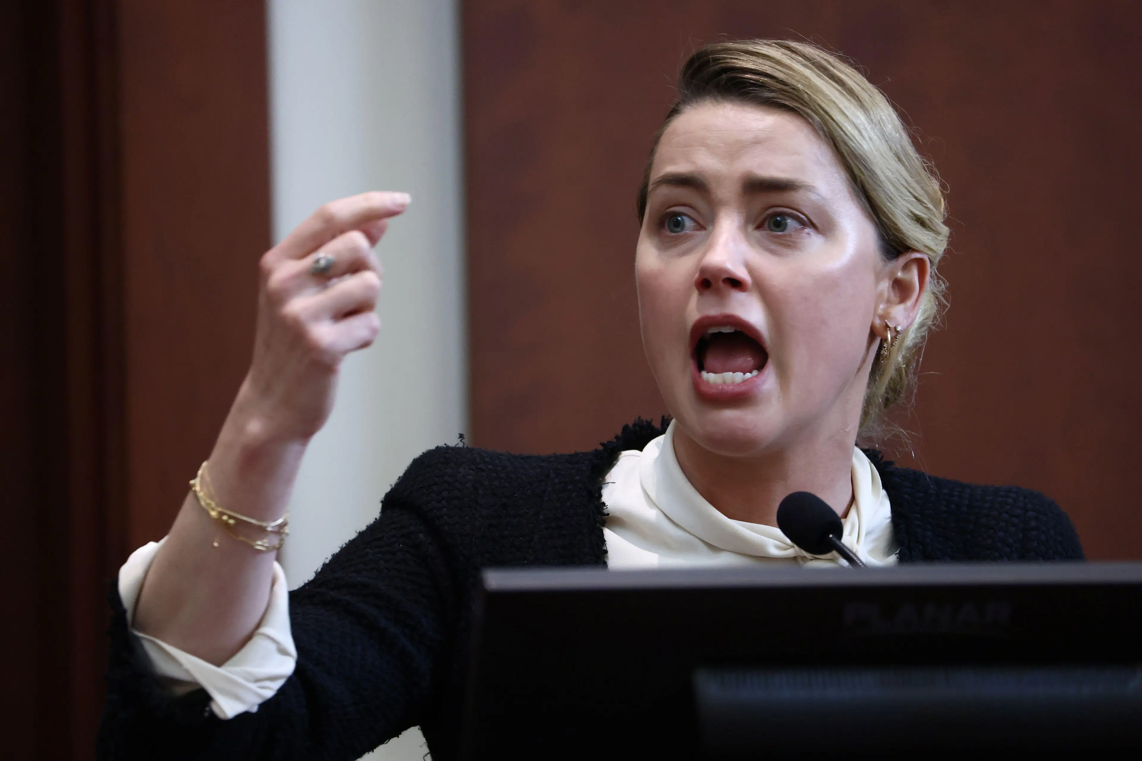 Actor Amber Heard reacts on the stand in the courtroom at Fairfax County Circuit Court during a defamation case against her by ex-husband, actor Johnny Depp,