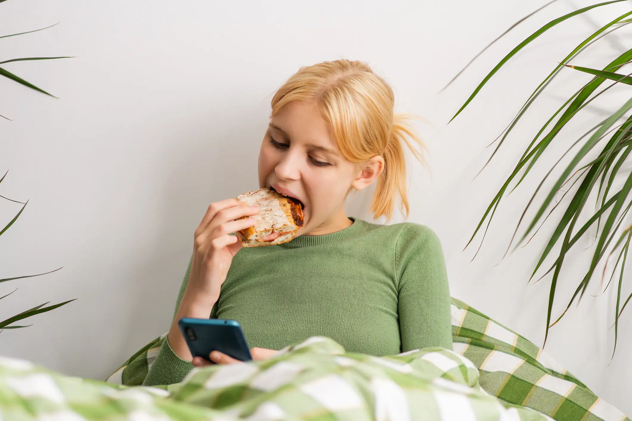 Bed rotting is often characterised as spending large amounts of time sat under the covers and scrolling social media (Getty Stock Images)