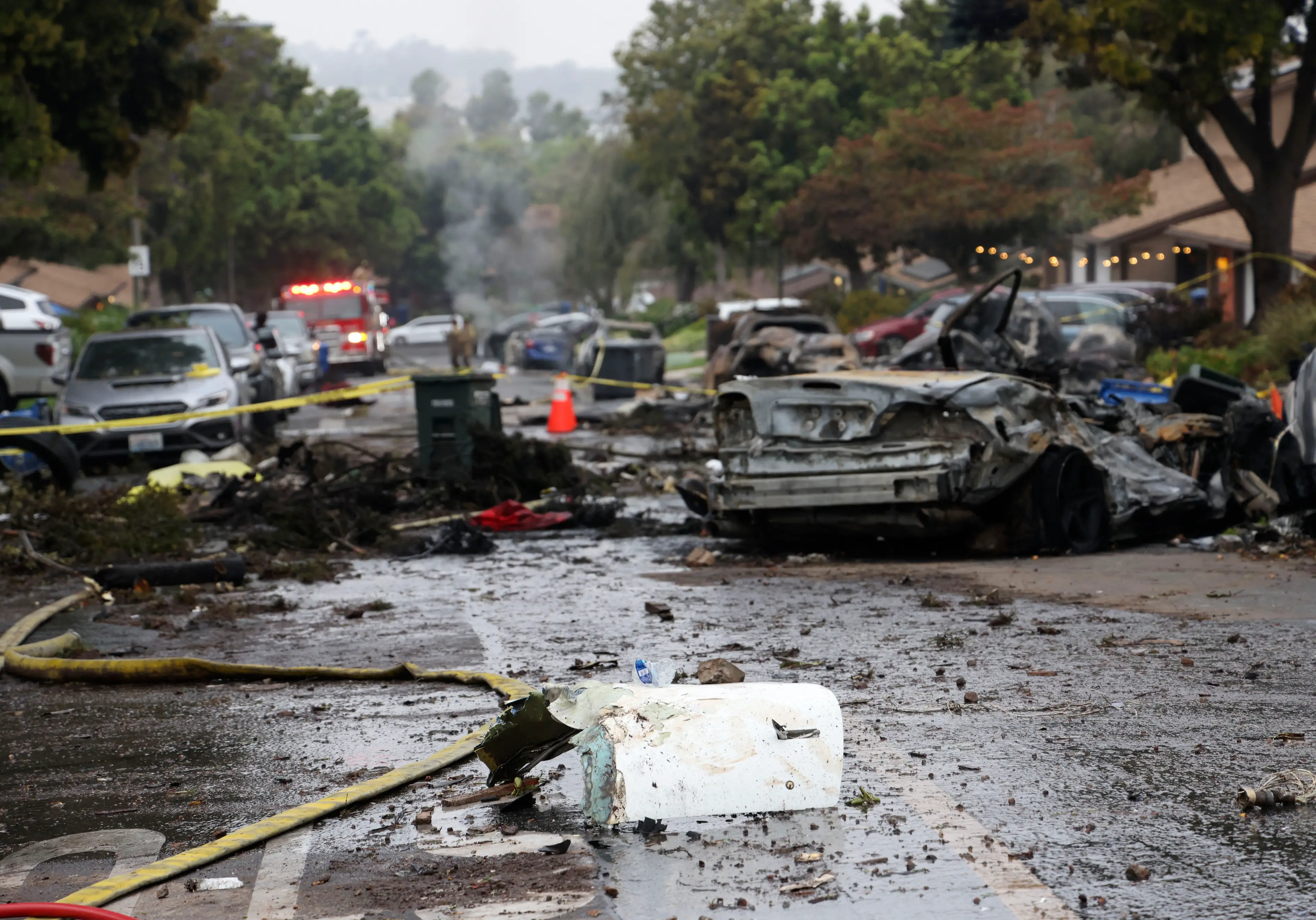 Debris is littered across the San Diego neighbourhood where the plane crashed on Thursday (SANDY HUFFAKER/AFP via Getty Images)