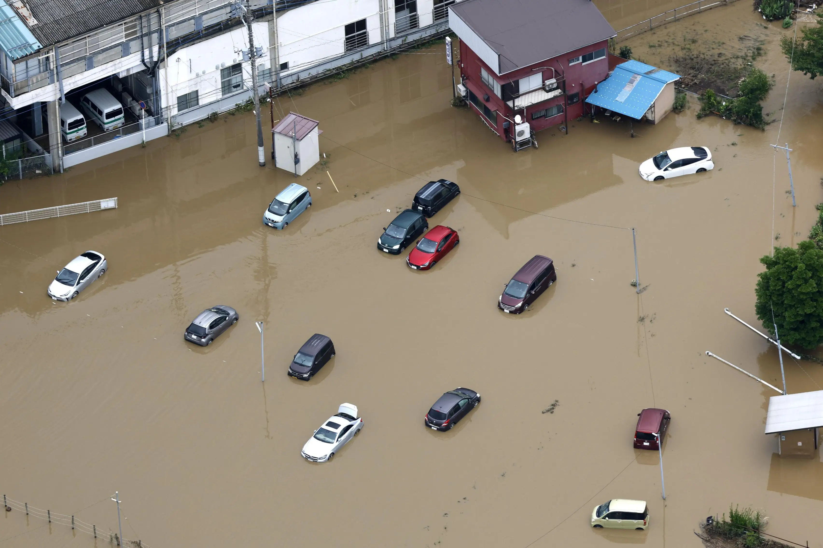 Cars submerged in floodwater after heavy rain in Oamishirasato (AP/PA Images)
