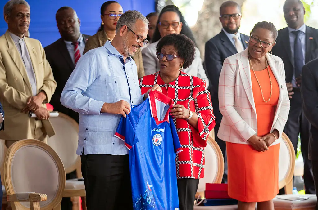 Haitian Prime Minister Alix Didier Fils-Aime receiving the now-banned jersey back in April (Clarens SIFFROY / AFP via Getty Images)