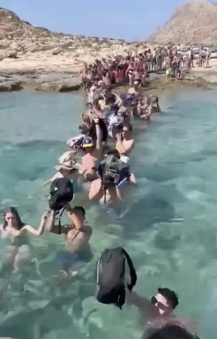 Wading through the water with their belongings over their head, it's not how you'd normally disembark a ferry. (Facebook/Patrick Ahlborn)