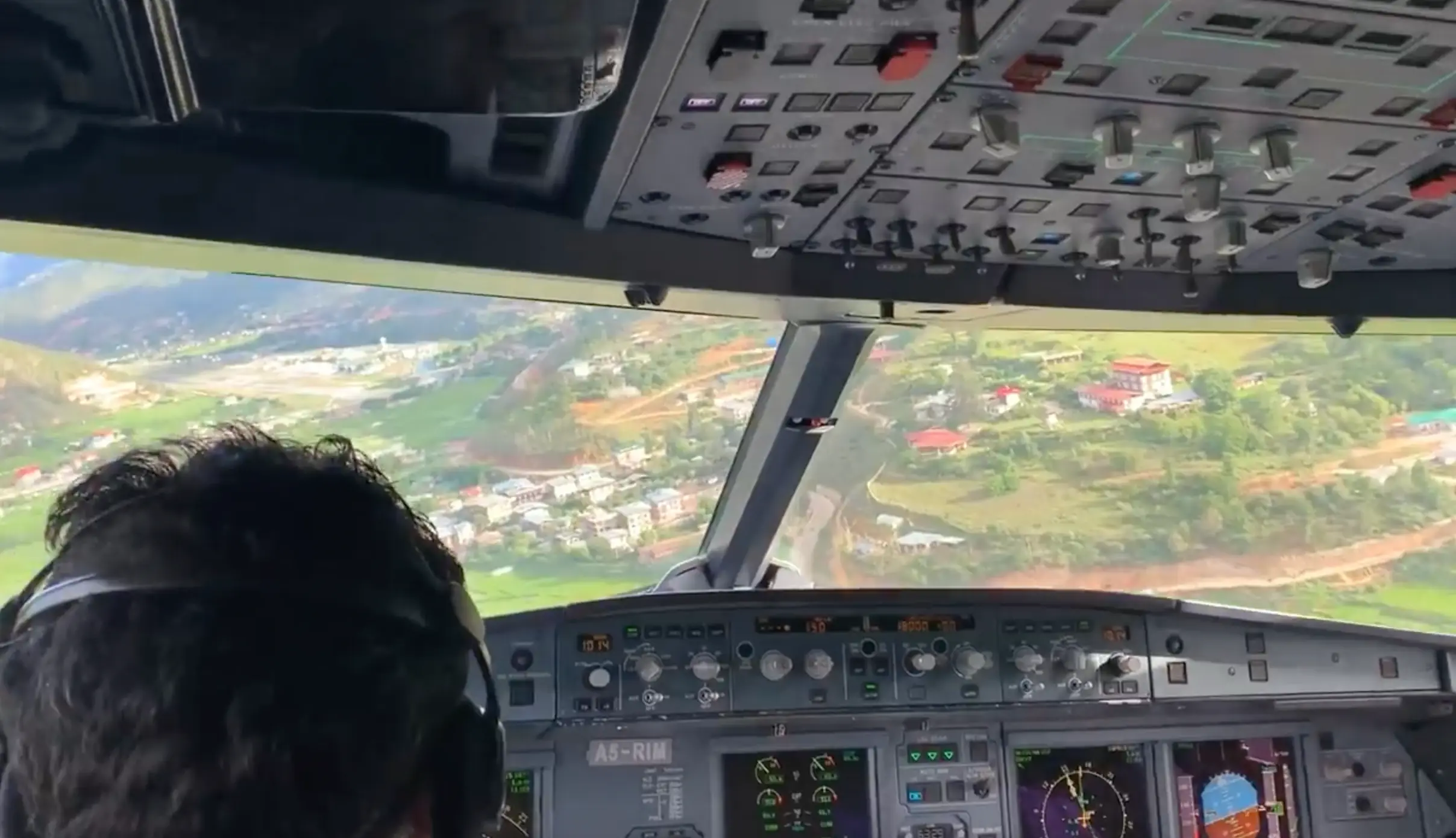If you squint and look closely, you can see the tiny strip of Paro airport's runway in the centre of pilot's view.