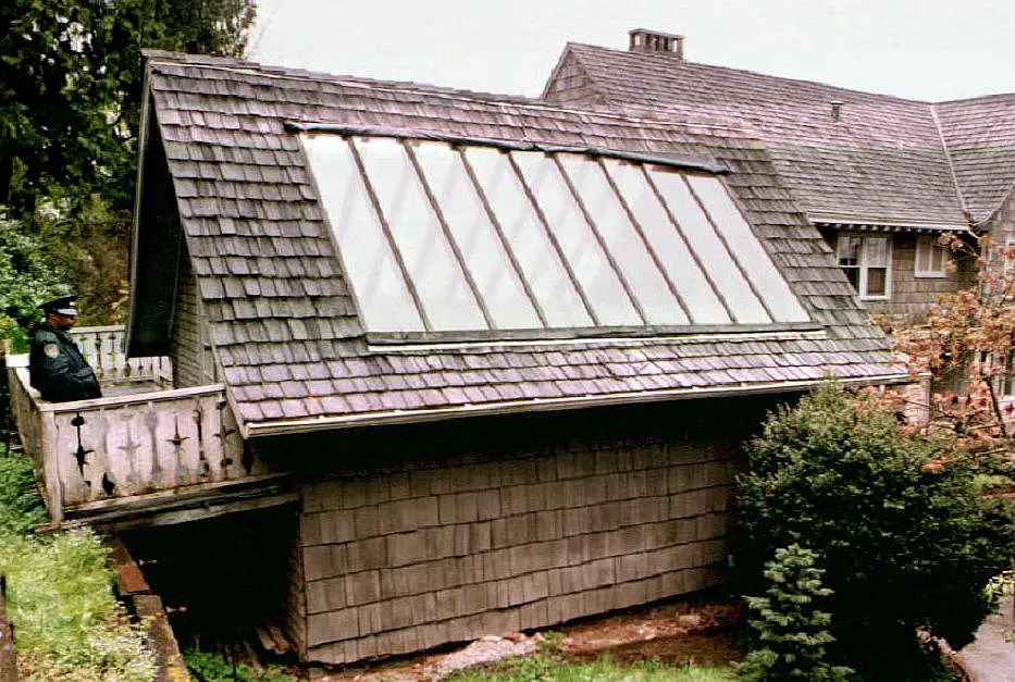 A police officer stood guard on the porch of the garage where Cobain was found (Photo by THERESE FRARE/AFP via Getty Images)