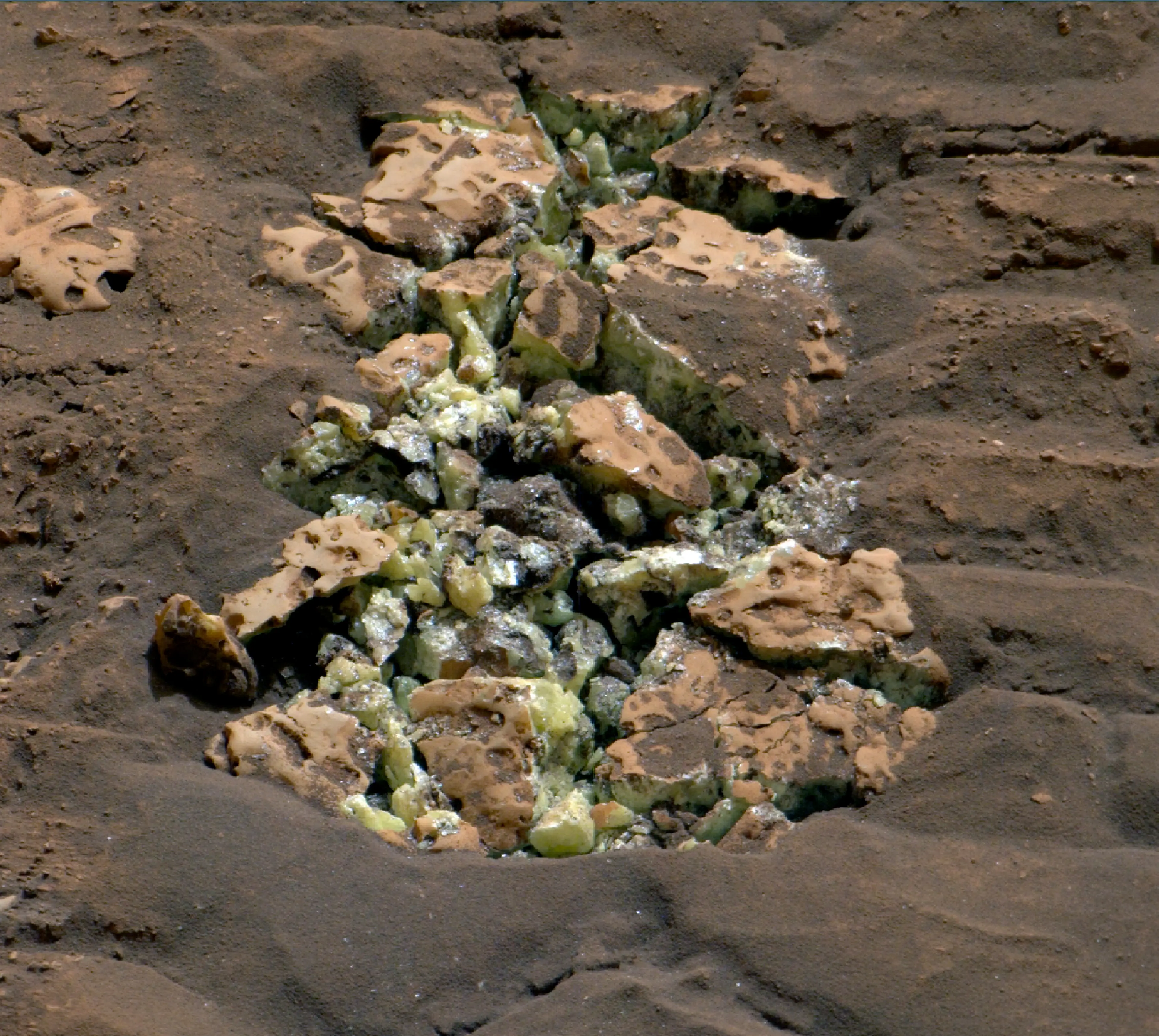 The yellow sulfur crystals inside the boulder. (SWNS/NASA)