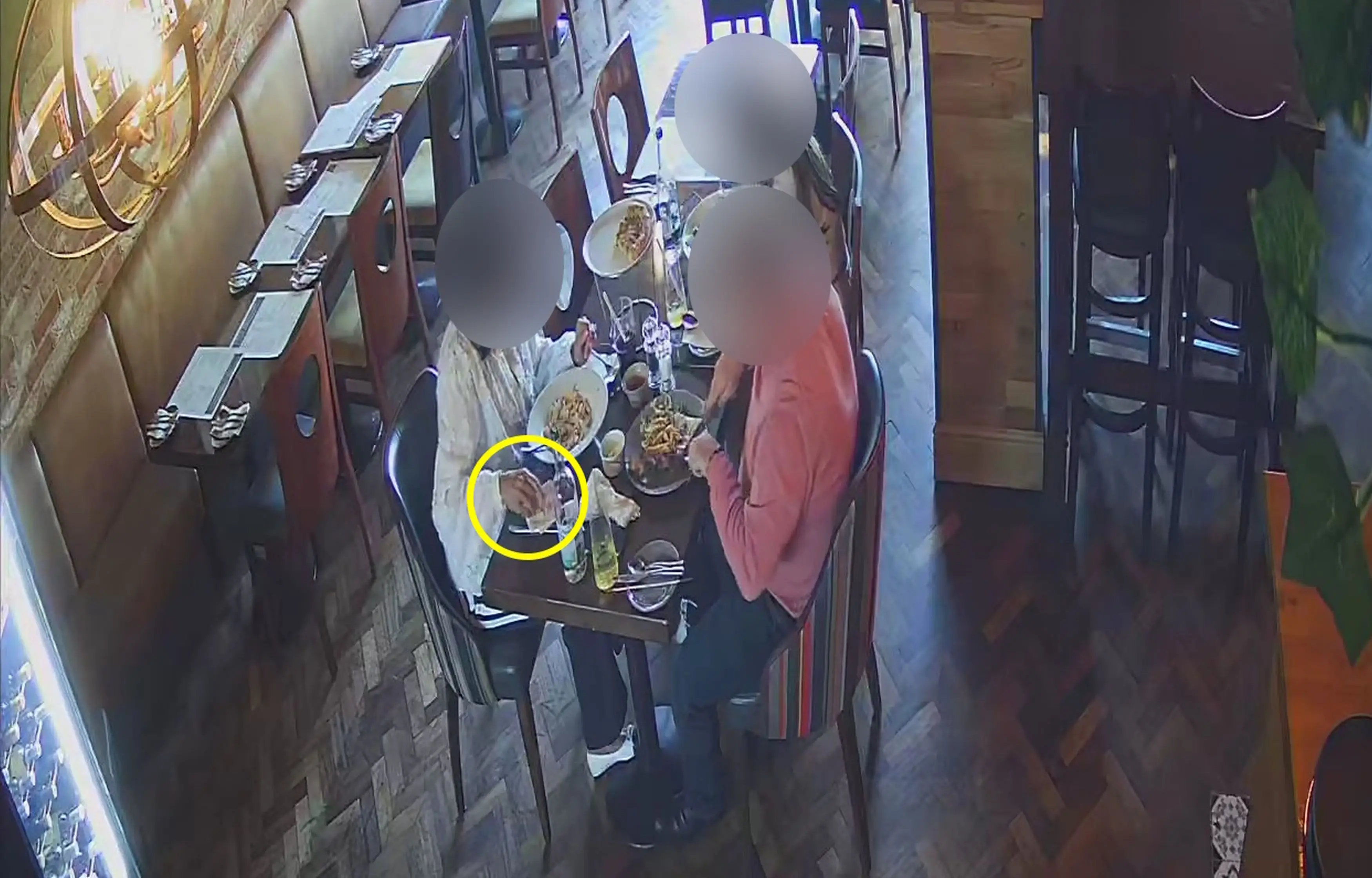 The CCTV then appears to show the woman placing the glass into her napkin before alerting a restaurant employee (Kennedy News and Media)