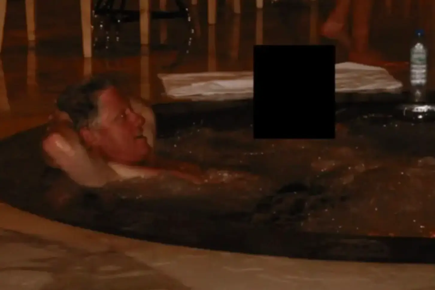The former president relaxing in what appears to be a hot tub (Department of Justice)