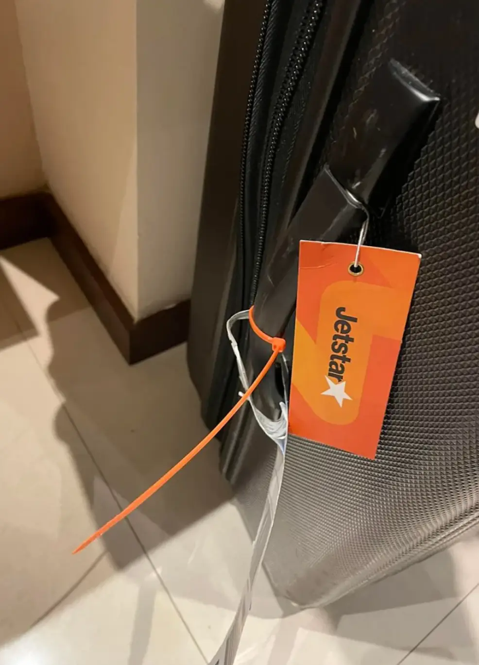 A woman was left puzzled when her suitcase arrived with an orange cable tie attached.