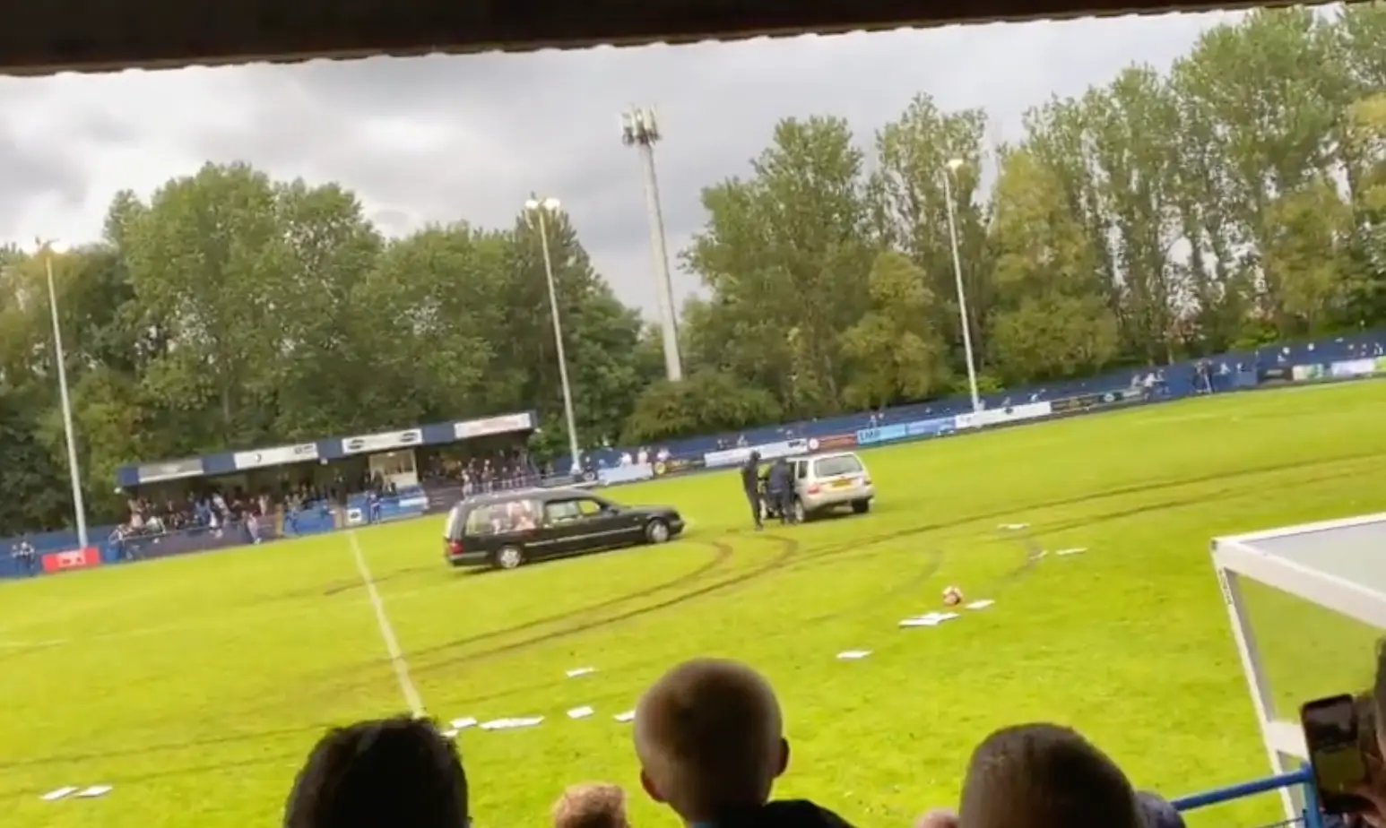 Men wearing masks exited the hearse.