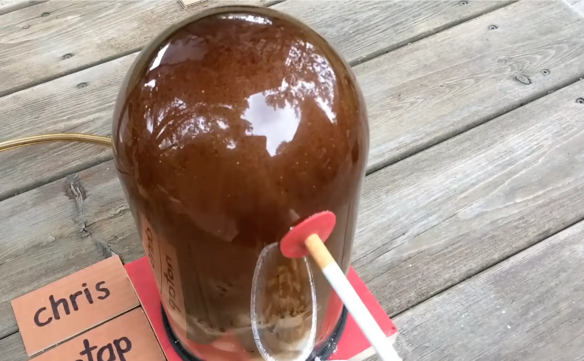 The bell jar was blackened by tar by the end of the experiment (YouTube/@chrisnotap)