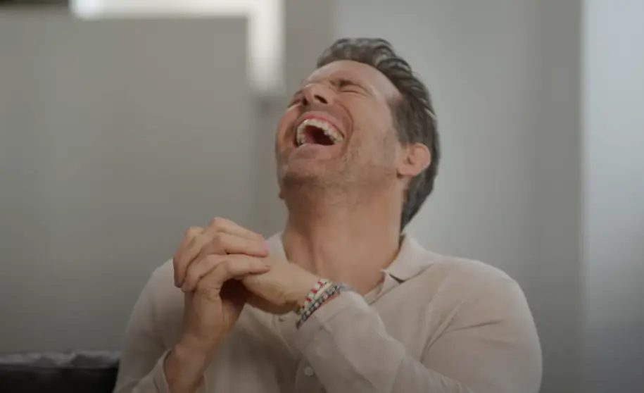 Reynolds couldn't keep it in. (YouTube/People)