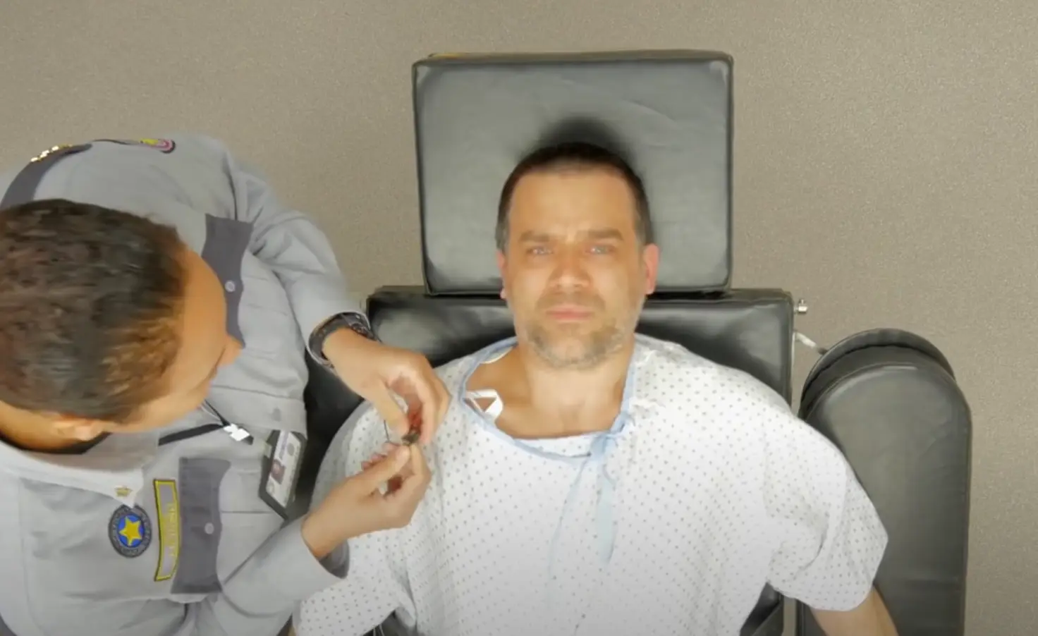 A microphone and heart monitor are attached to the inmate.