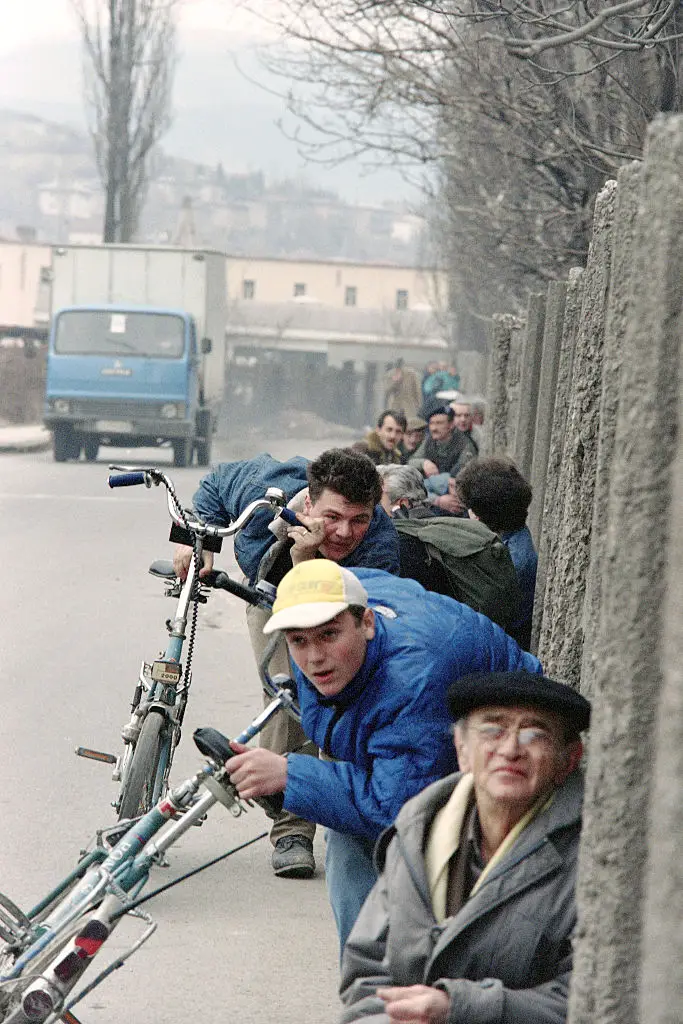 Sarajevo residents keep close to the wall to try and avoid snipers in 1993 (VINCENT AMALVY/AFP via Getty Images)