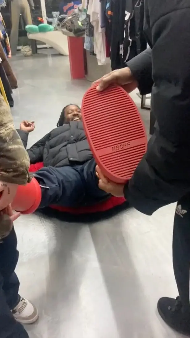 The lad was seen panicking as he couldn't get the designer boots off his feet.