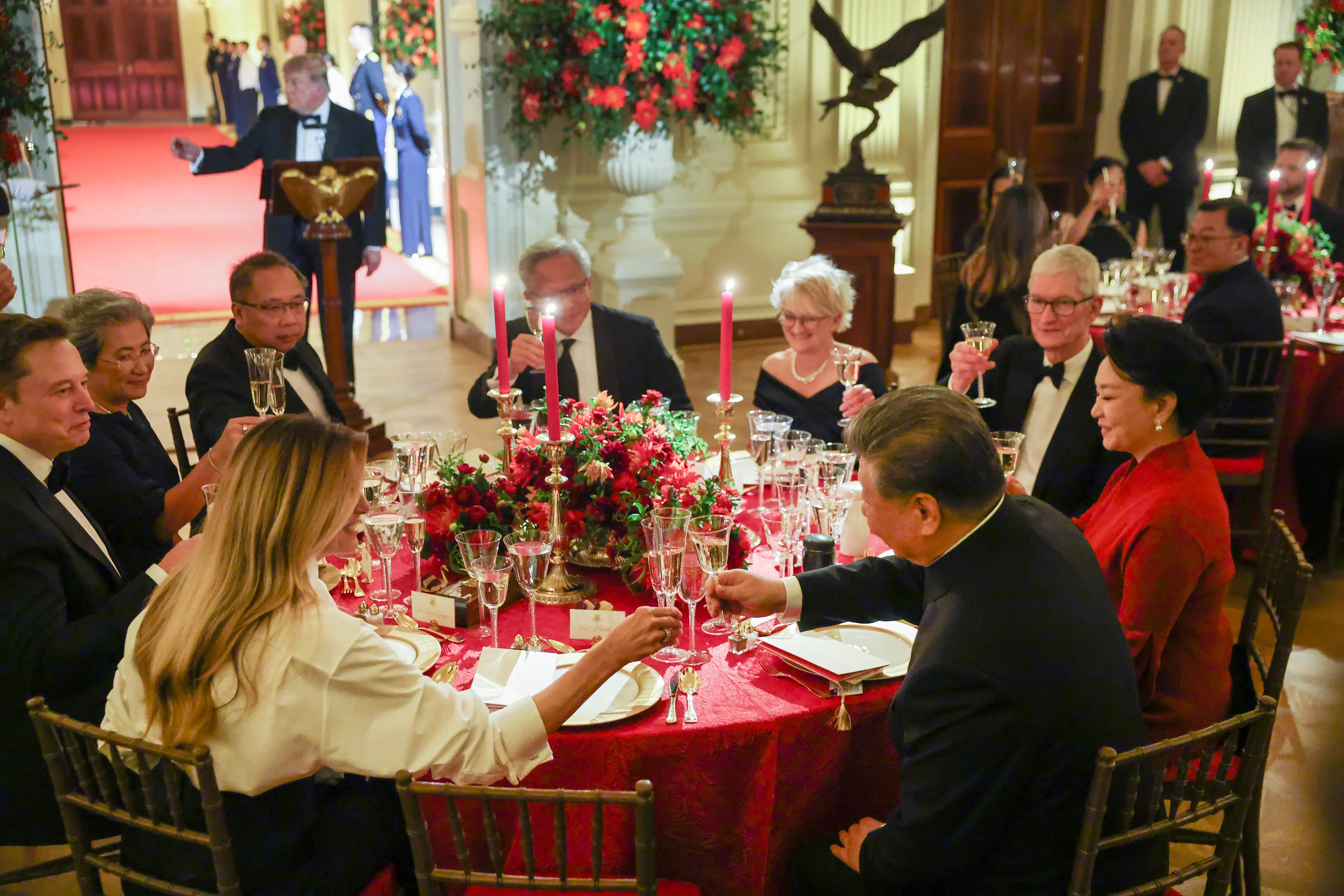 Xi seen clinking glasses with Melania while sat alongside their wealthy dinner guests (Kevin Dietsch/Getty Images)